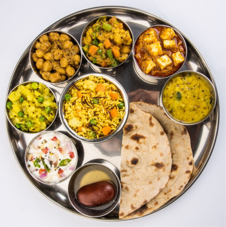 Indian vegetarian thali served with rice, curry, vegetables and flatbread